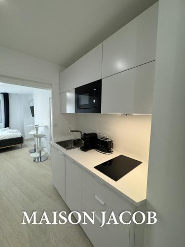 a kitchen with white cabinets and a counter top at Maison Jacob - Hyper centre - Maison historique - Air conditioning - Wifi in Avignon