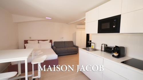 a room with a bed and a kitchen with a table at Maison Jacob - Hyper centre - Maison historique - Air conditioning - Wifi in Avignon