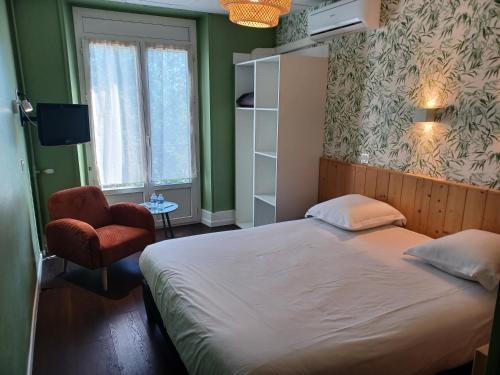 a bedroom with a bed and a chair and a window at Hotel Le Colibri in Aix-les-Bains