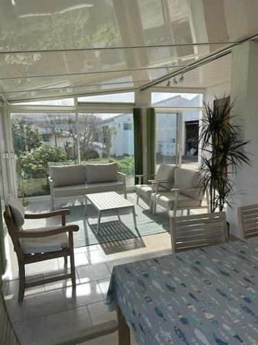 a screened in porch with chairs and a table at Terredesel Oleron in Saint-Denis-dʼOléron