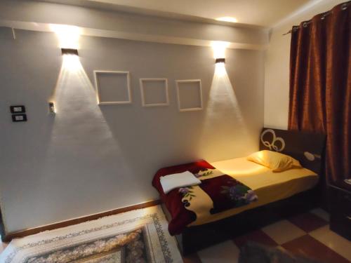 a bedroom with a bed with lights on the wall at sunset in Abu Simbel