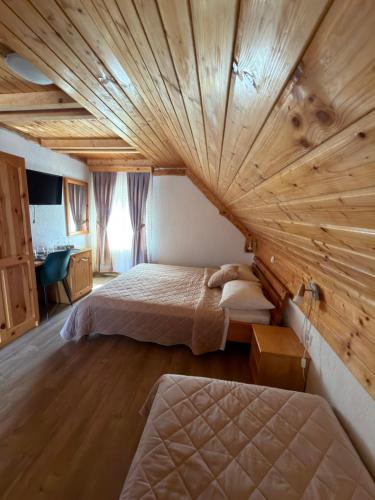 a bedroom with two beds and a wooden ceiling at Guest House Plitvice Waterfall in Plitvička Jezera