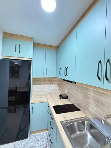 a kitchen with blue cabinets and a sink at luxury studio's J&M in Sarandë