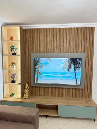 un soggiorno con una televisione su una parete di legno di luxury studio's J&M a Sarandë