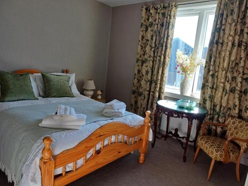 a bedroom with a bed with a window and a chair at Number 47 in Hawick