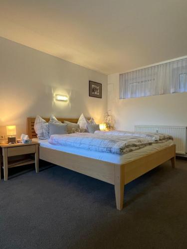 a bedroom with a large bed with blue sheets at Zeit/-Los in Irdning