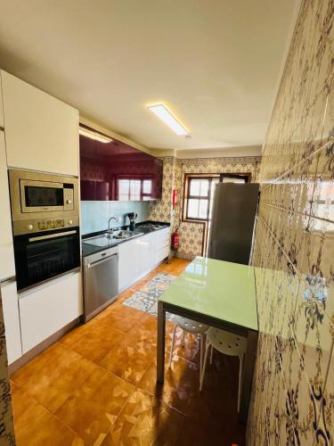 a kitchen with a green table and a stove at Stay & Smile Apartment in Póvoa de Varzim