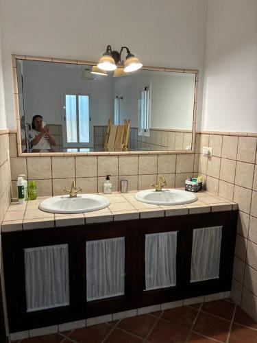 a bathroom with two sinks and a large mirror at Casa Las Adelfas in Isla Cristina