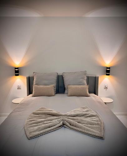 a bedroom with a bed with a bow blanket on it at Casa Bianca - Maison à Orléans in Orléans