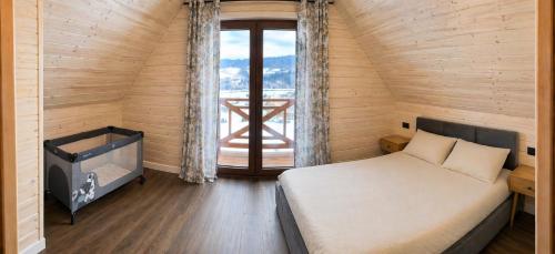 a bedroom with a bed and a large window at Domek Pod-Górski in Baligród