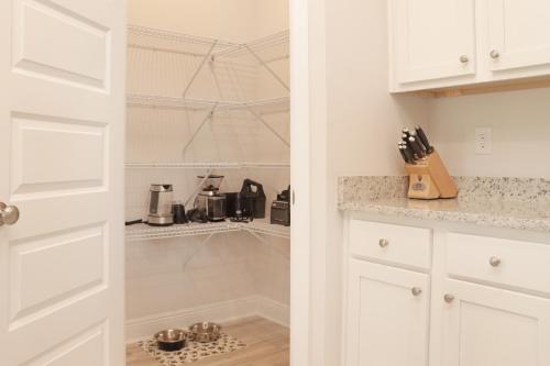 a kitchen with white cabinets and a pantry at Backwater Bliss by Pristine Properties Vacation Rentals in Saint Joe Beach