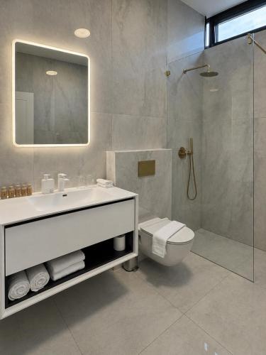 a bathroom with a sink and a toilet and a shower at Sea 300 Villa in Migdal