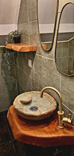 a bathroom with a stone sink and a mirror at A Toca, Complete townhouse apartment in Monchique