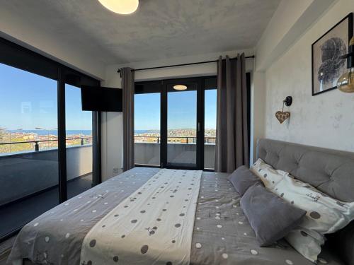 a bedroom with a bed and large glass windows at Киво апарт Созопол in Sozopol