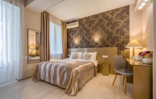 a hotel room with a bed and a desk and a chair at Iliani Hotel in Tbilisi City