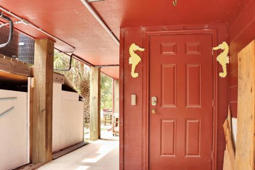 a red door with gold paint on the side of a house at Wales Pod by Pristine Properties Vacation Rentals in Indian Pass