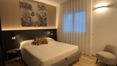 a small bedroom with a bed and a chair at Palladio13 in San Benedetto del Tronto