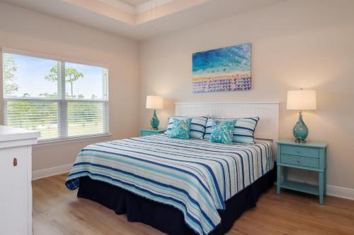 a bedroom with a bed and two lamps and a window at WindMark Beach North by Pristine Properties Vacation Rentals in Saint Joe Beach
