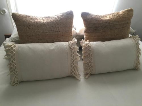 two pillows sitting on top of a bed at Casa Del Fogón, En La Calle Del Castillo in Vejer de la Frontera