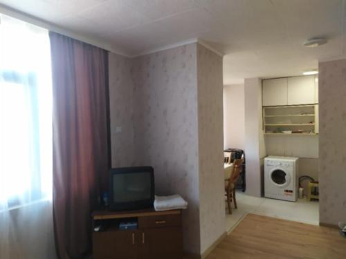 a living room with a tv on a dresser in a room at Студио Търговище in Targovishte