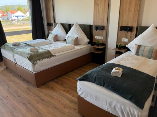 two beds in a room with a window at AS-Hotel NOM in Northeim