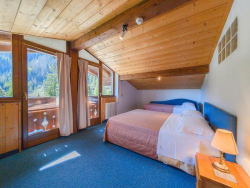 a bedroom with a bed and a large window at Leres Pastry Hotel in Sottoguda