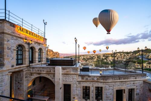 an old building with hot air balloons in the sky at Aurelia Cave Cappadocia - Special Class in Nevşehir