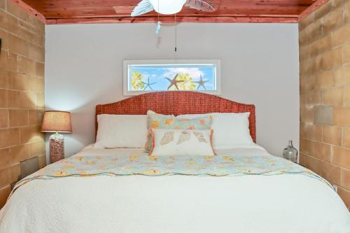 a bedroom with a white bed with a wooden headboard at Quarters B by Pristine Properties in Mexico Beach