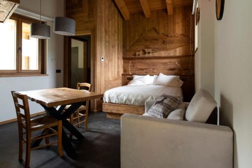 a bedroom with a bed and a table and a chair at Locanda Il Campo della Quercia in San Damiano Macra