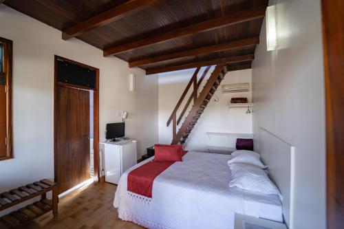a bedroom with a white bed and a staircase at Pousada Cachoeira Poço Encantado in Alto Paraíso de Goiás