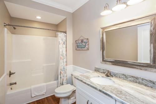 a bathroom with a toilet sink and a mirror at Treasure Road by Pristine Properties Vacation Rentals in Indian Pass