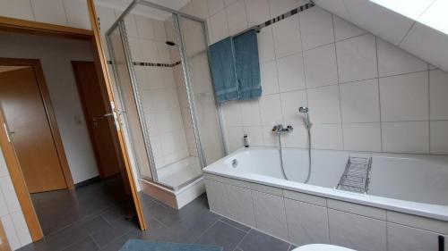 a bathroom with a bath tub and a shower at Nordmannsland I in Sudermarsch