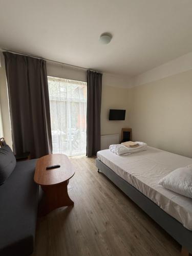 a bedroom with a bed and a table and a window at Rybitwa Karwia in Karwia