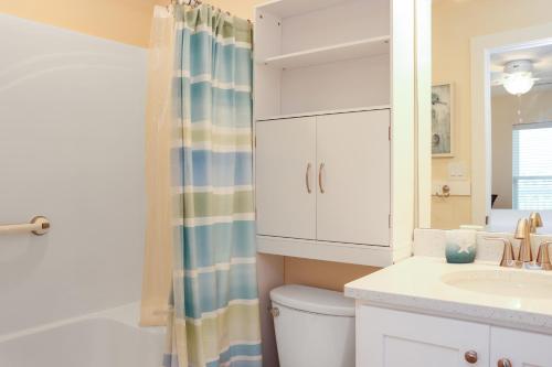 a bathroom with a toilet and a sink and a mirror at Pelican Roost E by Pristine Properties Vacation Rentals in Mexico Beach