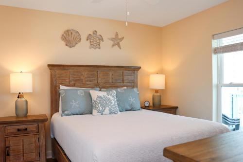 a bedroom with a large bed with blue pillows at Pelican Roost E by Pristine Properties Vacation Rentals in Mexico Beach