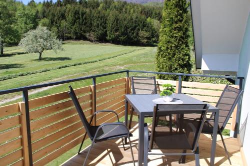 a patio with a table and chairs on a balcony at Apartma Luvita in Golnik