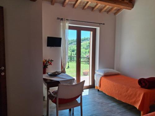 a bedroom with a bed and a desk and a window at Masseria Spadone in Civitella Casanova