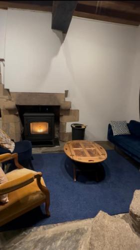 a living room with a table and a fireplace at Moulin de Lossulien in Le Relecq-Kerhuon