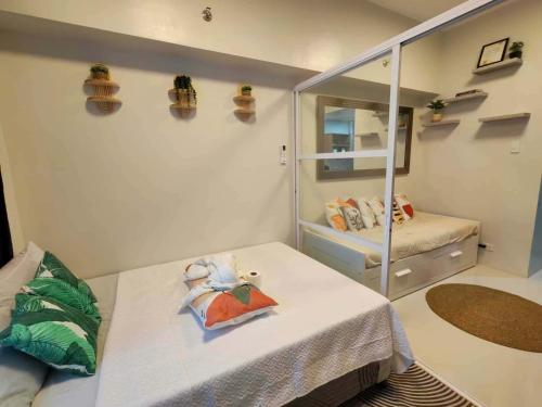 a small room with a bed and a mirror at Primeworld District Condo in Agus
