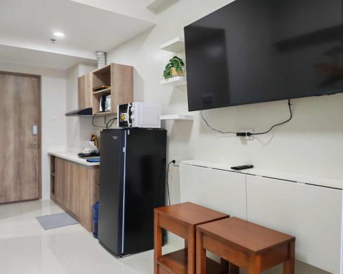 a kitchen with a black refrigerator and a table at Primeworld District Condo in Agus
