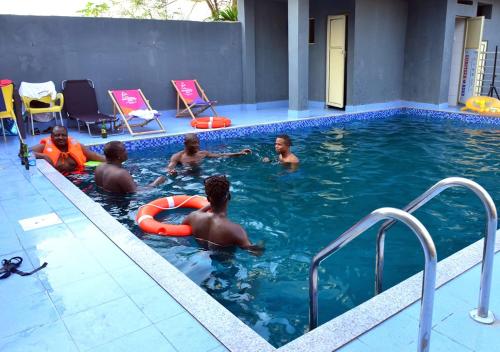 a group of people in a swimming pool at P Meridian Hotels in Awoyaya