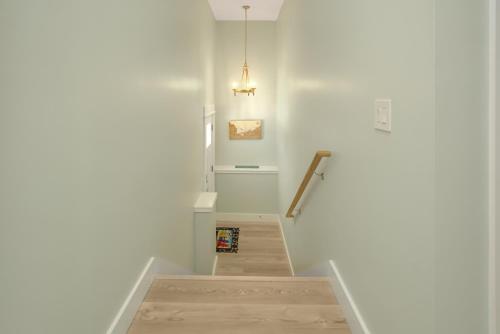 a stairway with a white wall and a light fixture at Shore Looks Good by Pristine Properties Vacation Rentals in Mexico Beach