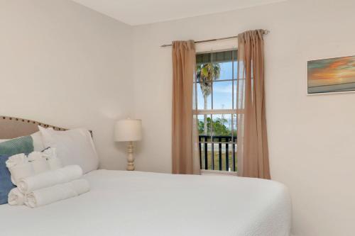 a bedroom with a white bed and a window at Sun Chaser by Pristine Properties Vacation Rentals in Cape San Blas