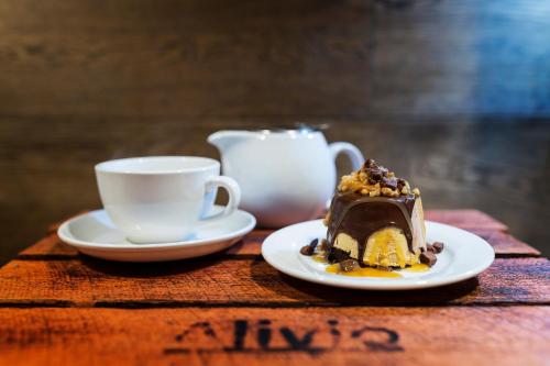 a piece of cake and a cup of coffee on a table at Alivio Tourist Park Canberra in Canberra
