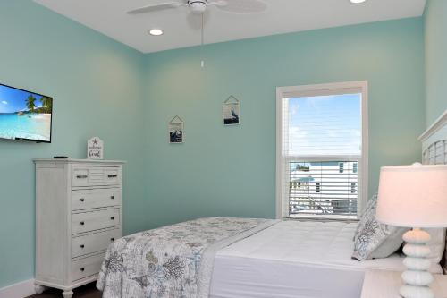 a bedroom with a bed and a dresser and a window at Windsong by Pristine Properties Vacation Rentals in Mexico Beach