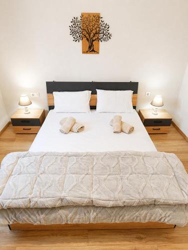 a bedroom with a large white bed with two lamps at Stella's House Mangana in Mángana
