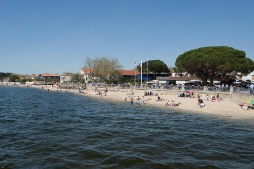 a group of people on a beach near the water at Les libellules in Andernos-les-Bains