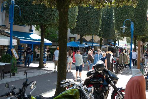 a group of people walking down a street with motorcycles at Les libellules in Andernos-les-Bains