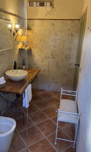 a bathroom with a sink and a toilet and a chair at Masoala Forest in Piera