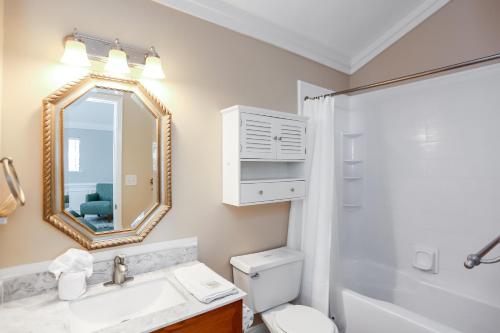 a bathroom with a sink and a toilet and a mirror at A Swell Life by Pristine Properties Vacation Rentals in Cape San Blas
